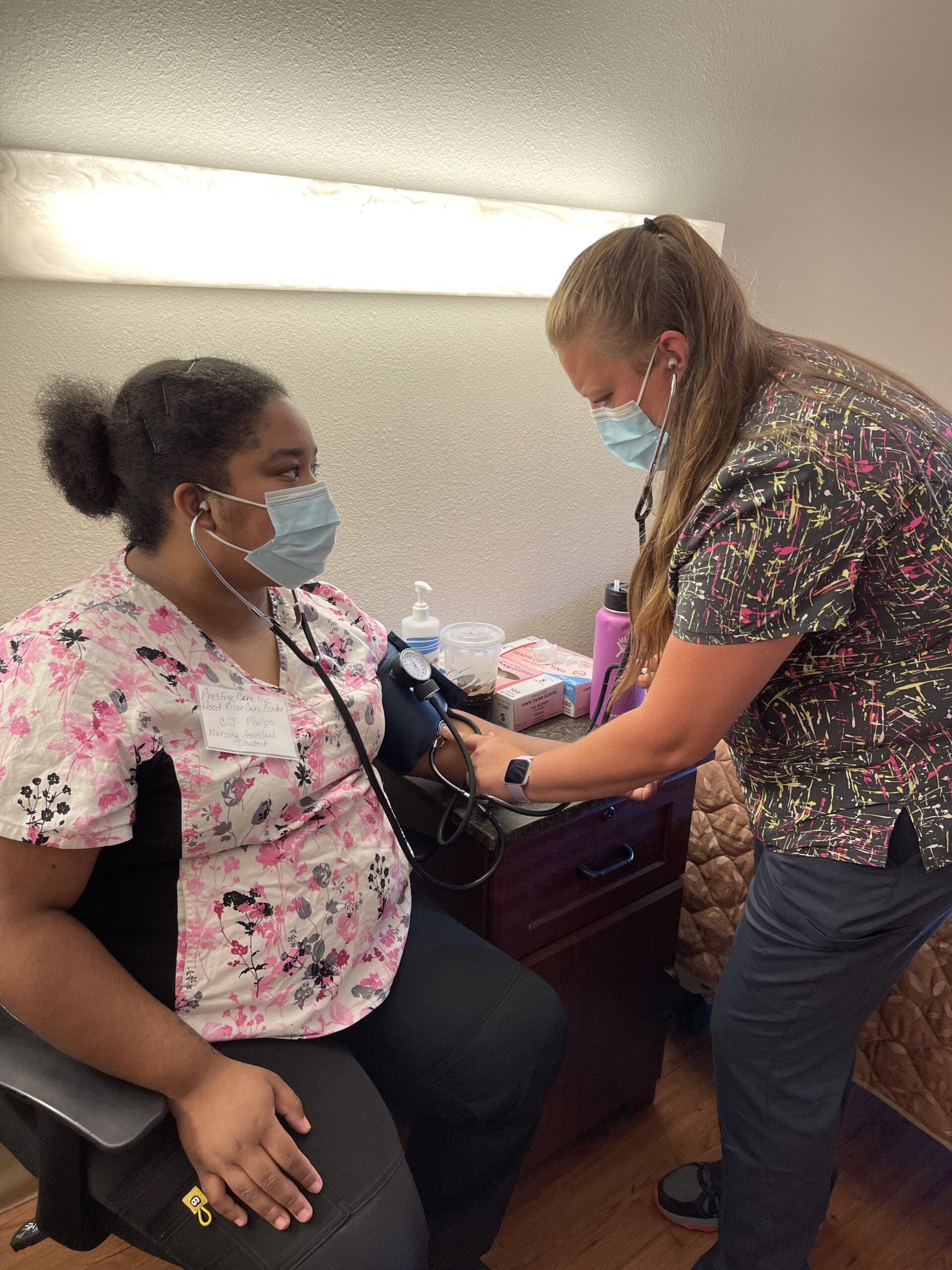Connie (right) practicing taking blood pressure.